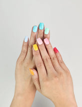 Model wearing Fruit Punch handmade Singapore press on nails in bright fruity colors – close-up view